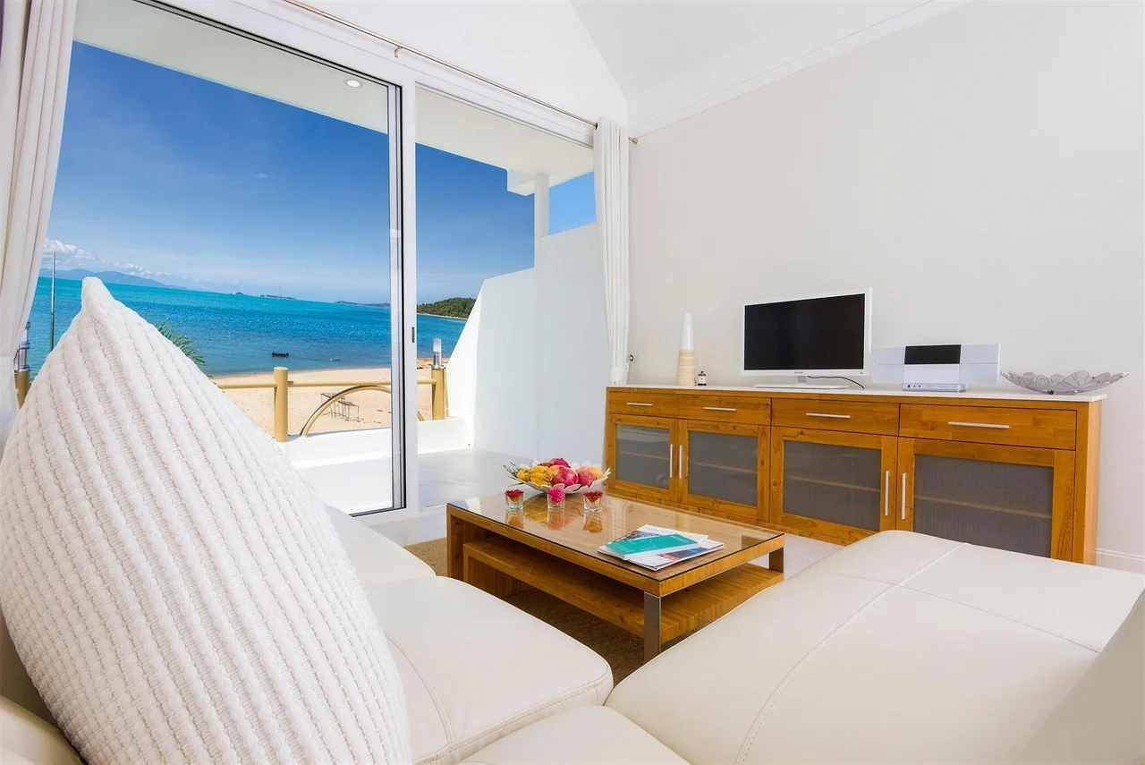 A sofa facing the open doors and the water